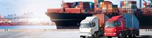 twee_vrachtwagens_op_een_haven_met_containerschippen_op_de_achtergrond